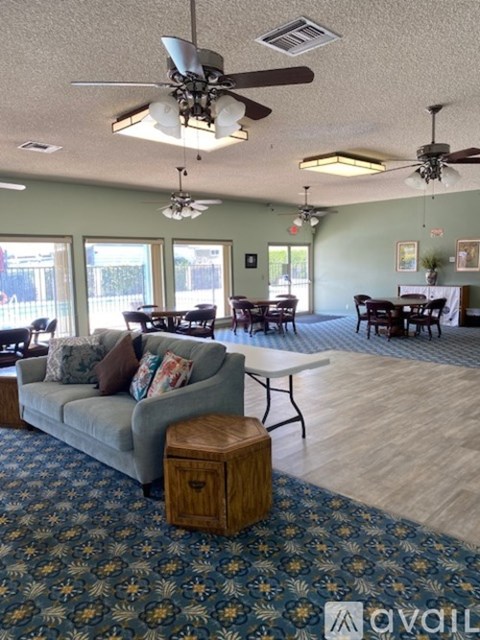 A living room with a grey couch and a ceiling fan.