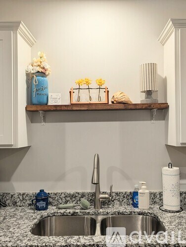 A kitchen with a sink and a shelf above it.