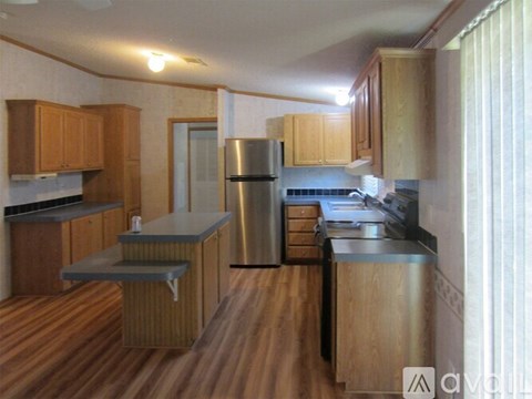 A kitchen with wooden cabinets and a stainless steel refrigerator.