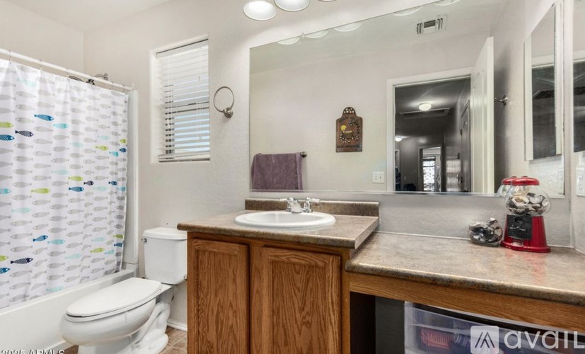 A bathroom with a toilet, sink, and shower curtain.