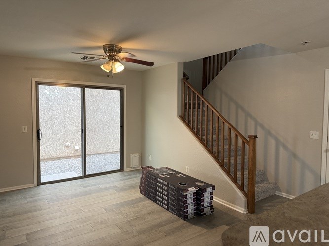 A room with a staircase and a ceiling fan.