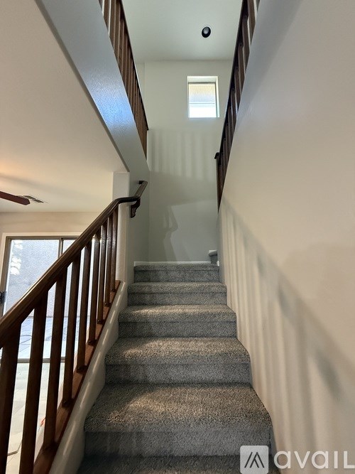 A staircase with a carpeted runner and wooden balusters.