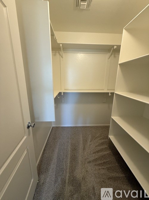 A hallway with white walls and a carpeted floor.