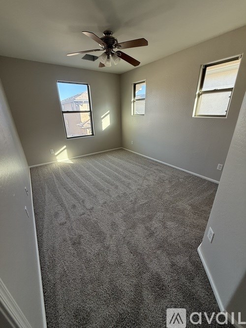 A room with a ceiling fan and carpeted floor.