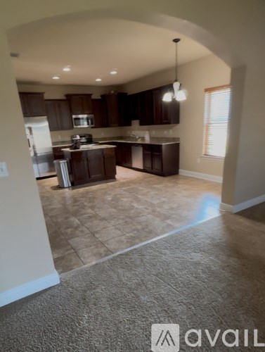 A kitchen with brown cabinets and a tile floor.
