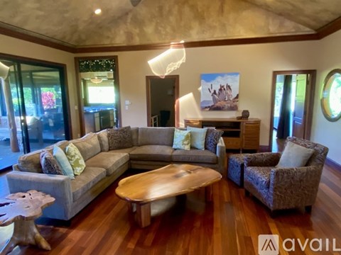 A living room with a grey couch, a wooden coffee table, and a painting on the wall.