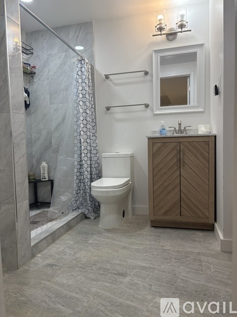 A bathroom with a toilet, sink, and shower.