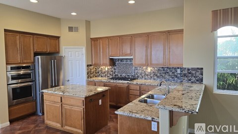 A kitchen with wooden cabinets and granite countertops.