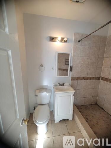 A small white bathroom with a toilet, sink and shower.