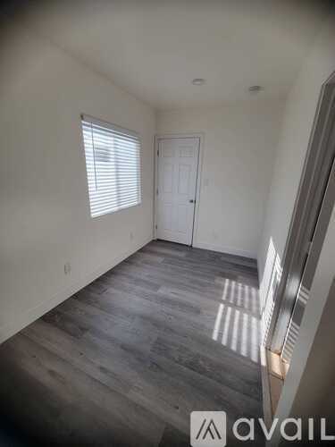 A room with a door and a window with blinds.
