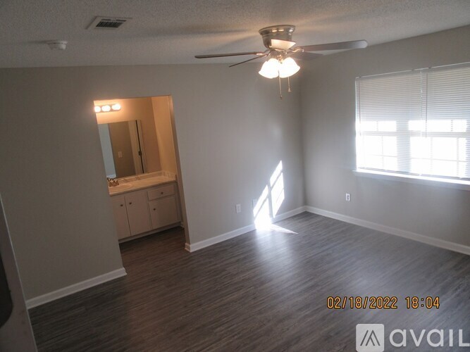 A room with a ceiling fan and a window with blinds.