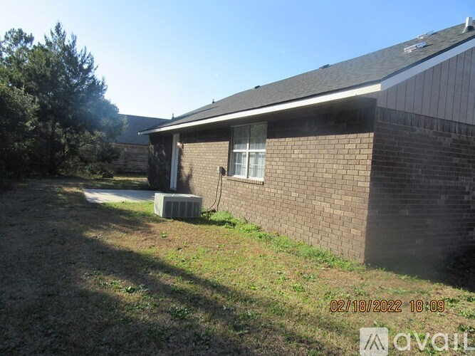 A house with a brown brick exterior and a white window is shown.