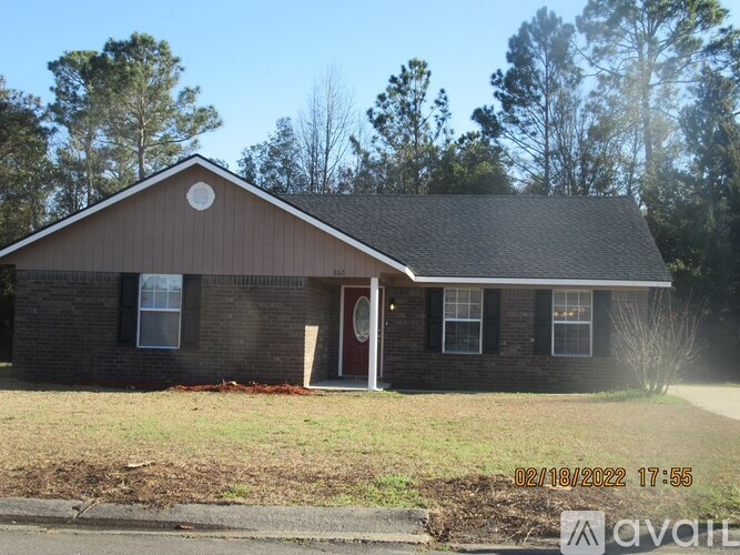 A house with a brown roof and a red door is for sale.