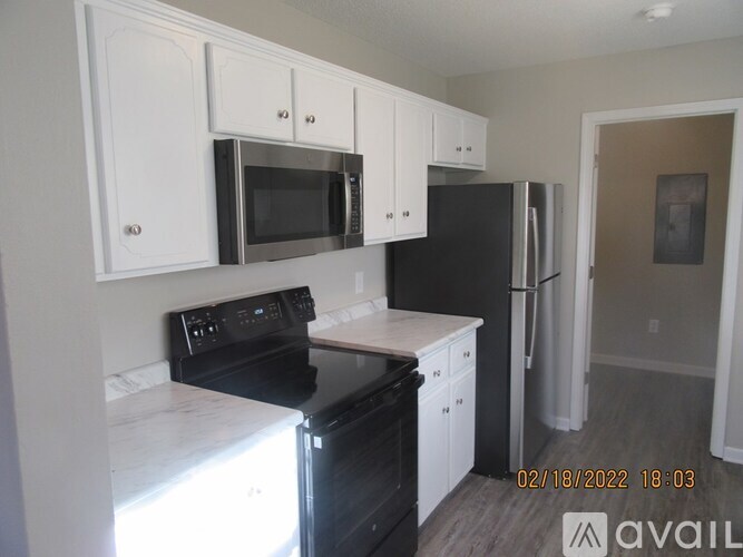 A kitchen with black appliances and white cabinets.
