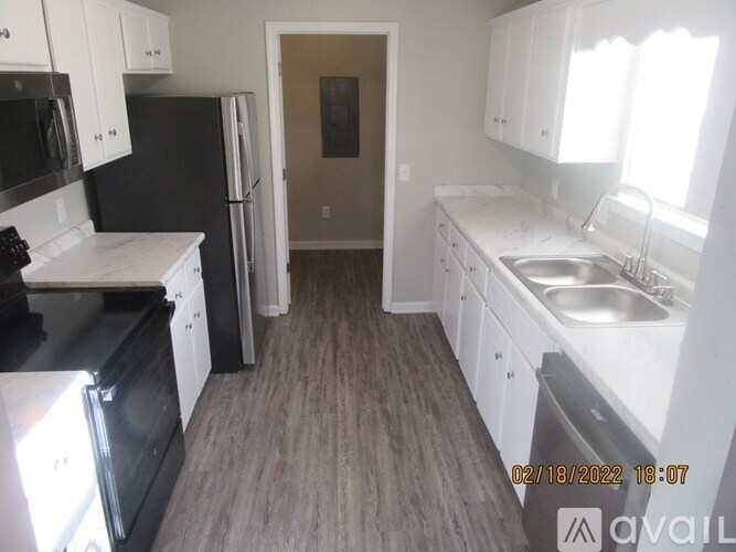 A kitchen with black appliances and white cabinets.