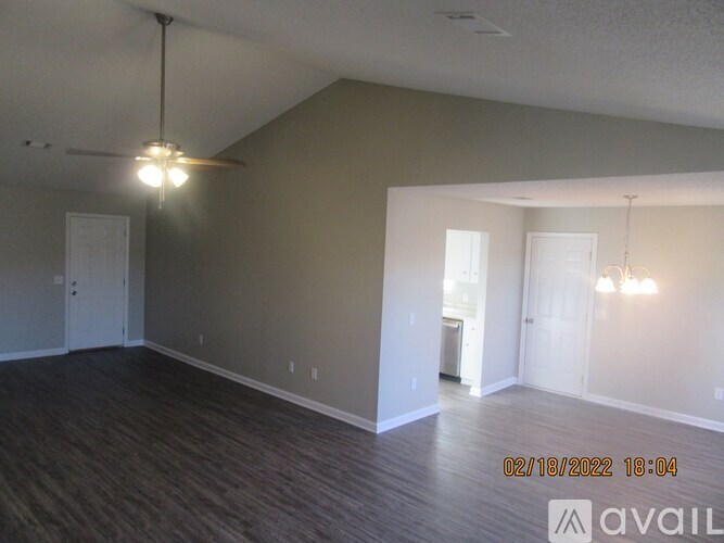 A room with a wooden floor and a ceiling fan.