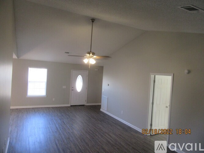 A room with a ceiling fan and a window.