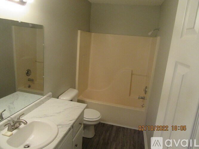 A bathroom with a toilet, sink, and bathtub.
