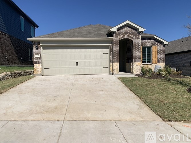 A house with a grey garage door and a stone archway entrance.