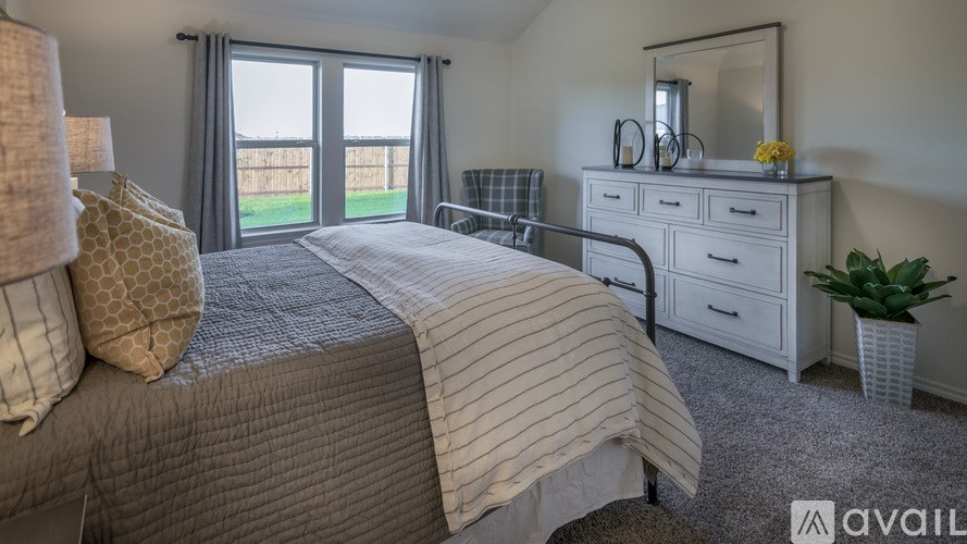 A bedroom with a large bed, a dresser, and a mirror.