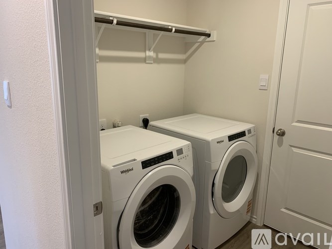 Two white washing machines in a small laundry room.