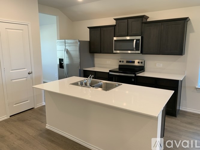 A kitchen with a white countertop and black cabinets.