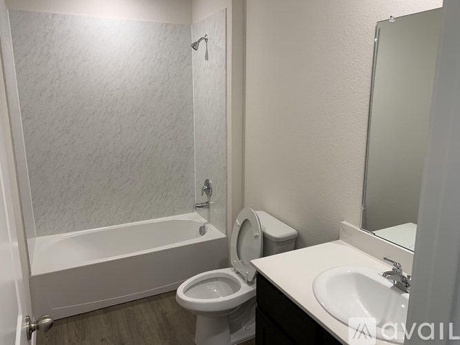 A bathroom with a toilet, sink, and bathtub.