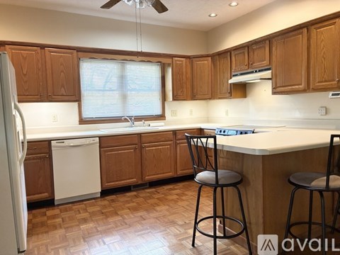 A kitchen with wooden cabinets and a white dishwasher.