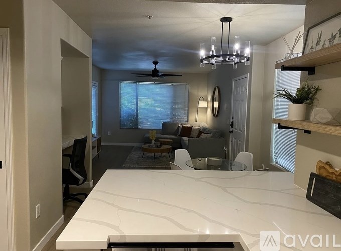 A kitchen with a white countertop and a ceiling fan.
