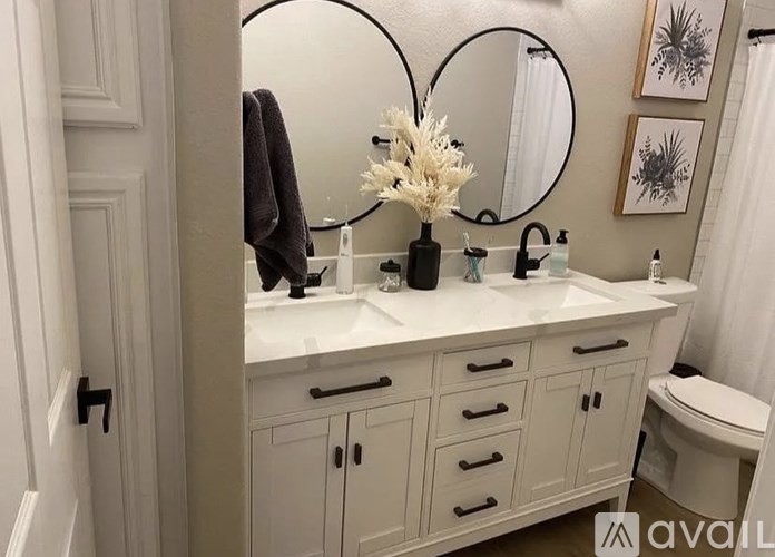 A bathroom with a white countertop and a round mirror.
