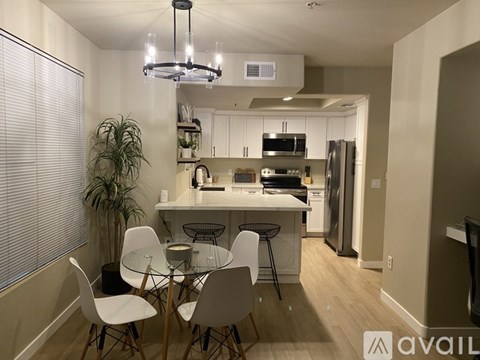A modern kitchen with a dining table and chairs.