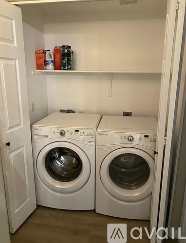 Two front loading washing machines in a small laundry room.