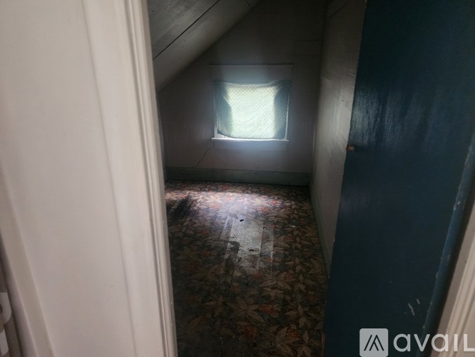 A room with a window and a carpeted floor.