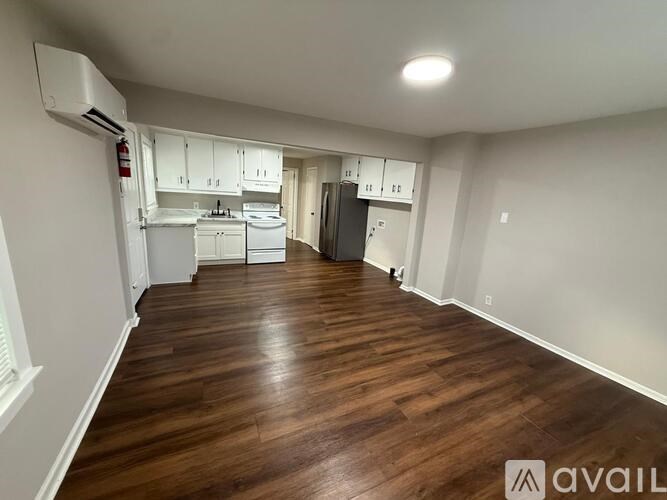 A kitchen area with white cabinets and a refrigerator.