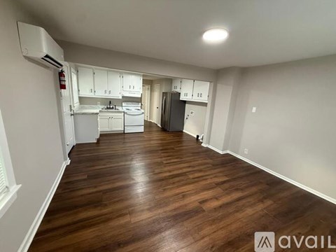 A kitchen area with white cabinets and a refrigerator.