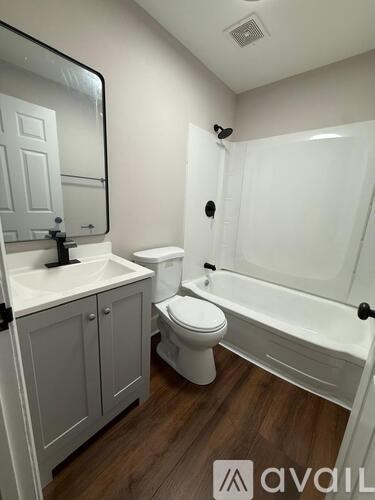 A bathroom with a white tub, toilet, and sink.