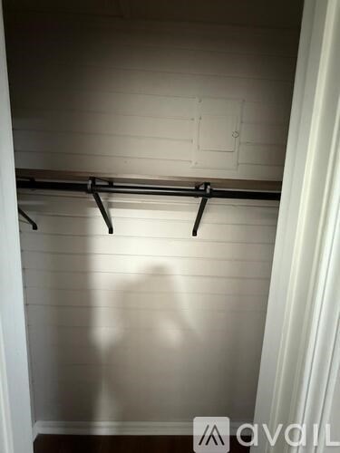 A white wall with a black bar hanging on it.