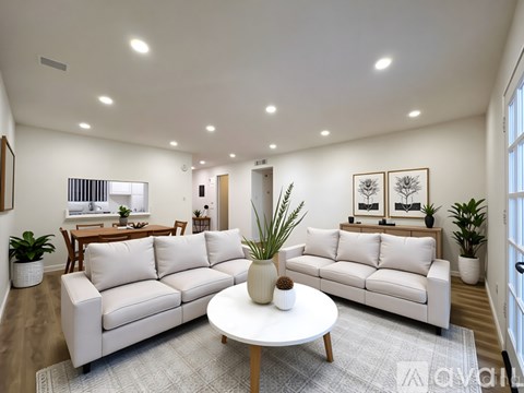 A living room with a white sofa and a coffee table.
