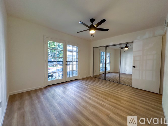 A room with wooden flooring and a ceiling fan.