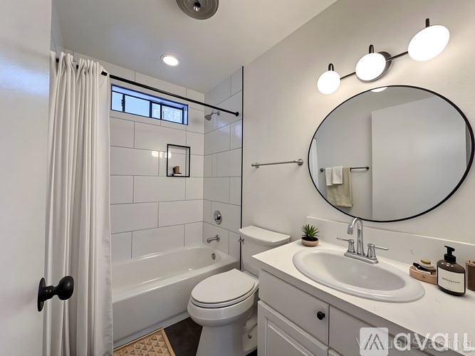 A bathroom with a white toilet, a white sink, and a white bathtub.