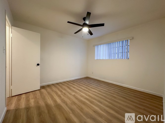 A room with wooden flooring and a ceiling fan.