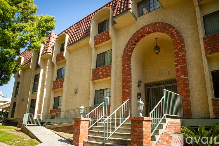 A building with a red roof and a staircase leading to the entrance.