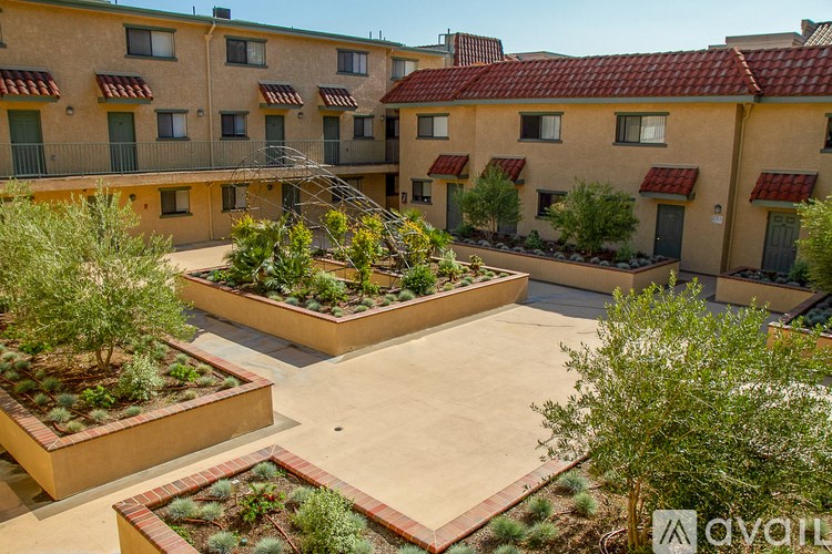 A courtyard with a fountain and planters in front of apartment buildings.