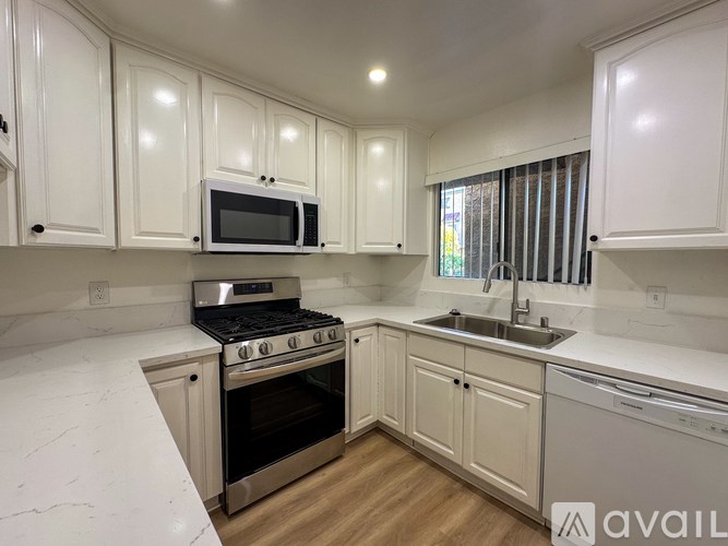 A kitchen with white cabinets and a stainless steel oven.