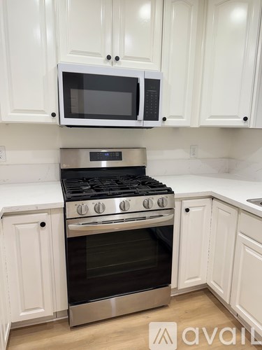 A kitchen with a stove and microwave above it.