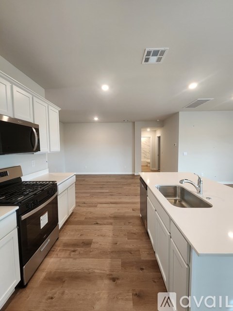 A kitchen with a black stove top oven and white cabinets.