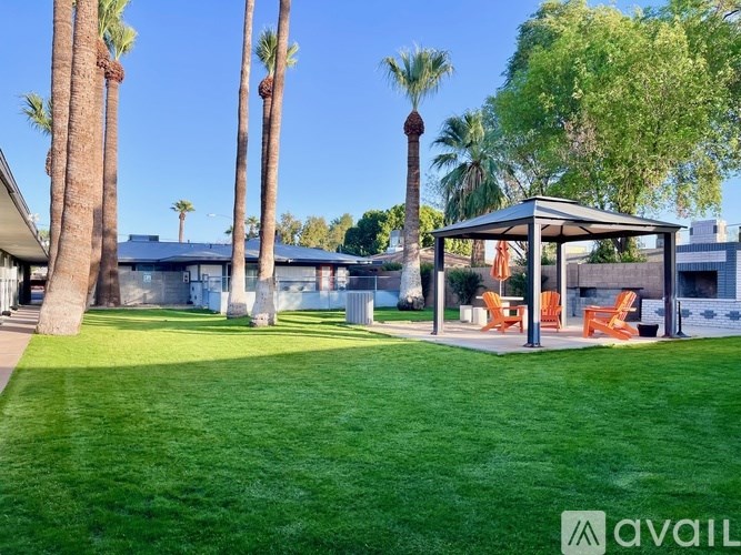 A house with a lawn and palm trees in front.