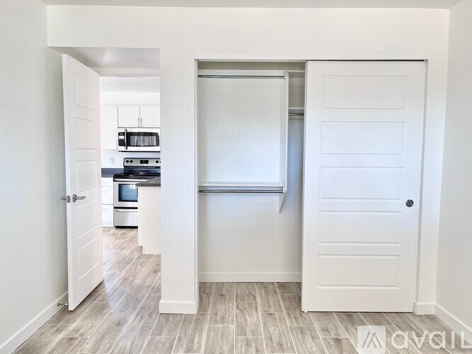 A white door is open to a kitchen.
