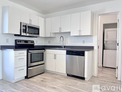 A kitchen with white cabinets and stainless steel appliances.