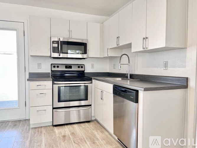 A kitchen with white cabinets and stainless steel appliances.